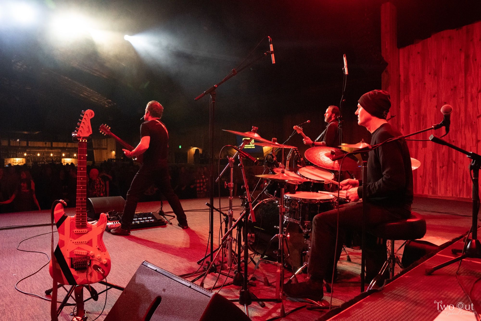 Drummer's-eye view of the Boot Barn Hall stage, guitarist mid-song with the dancing crowd behind