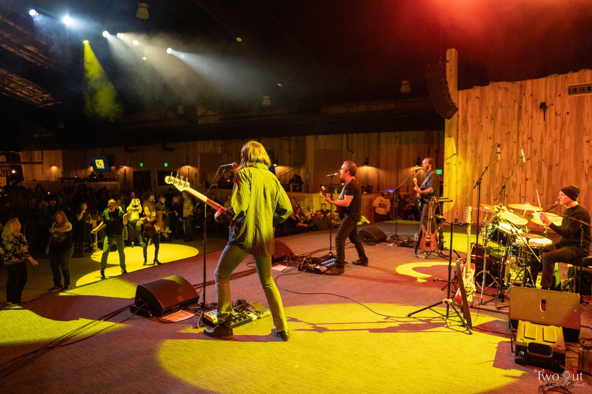 View from the crowd at Boot Barn Hall as Last Patrol Band performs under yellow and green stage light