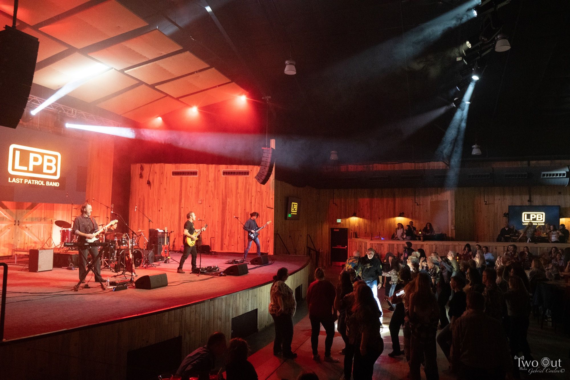 Last Patrol Band performing on the Boot Barn Hall stage under the LPB screen, crowd in front