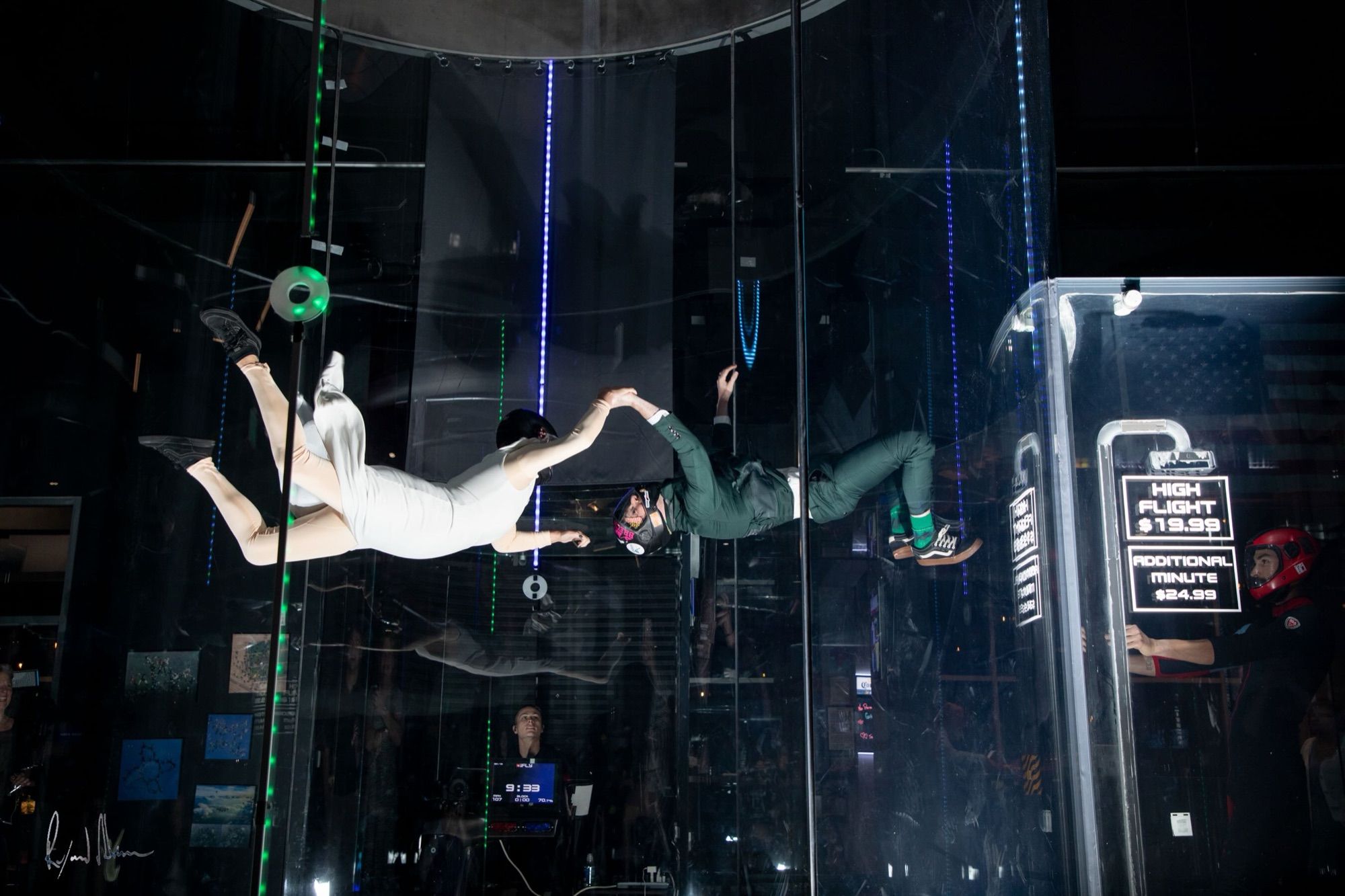 Gabriel and Chelsey in wedding dress and suit, flying hand in hand in the iFly tunnel