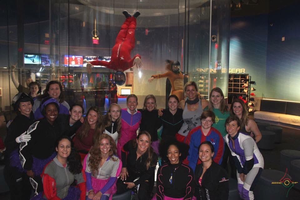 Group of women in a lounge area watching a flyer overhead in the tunnel