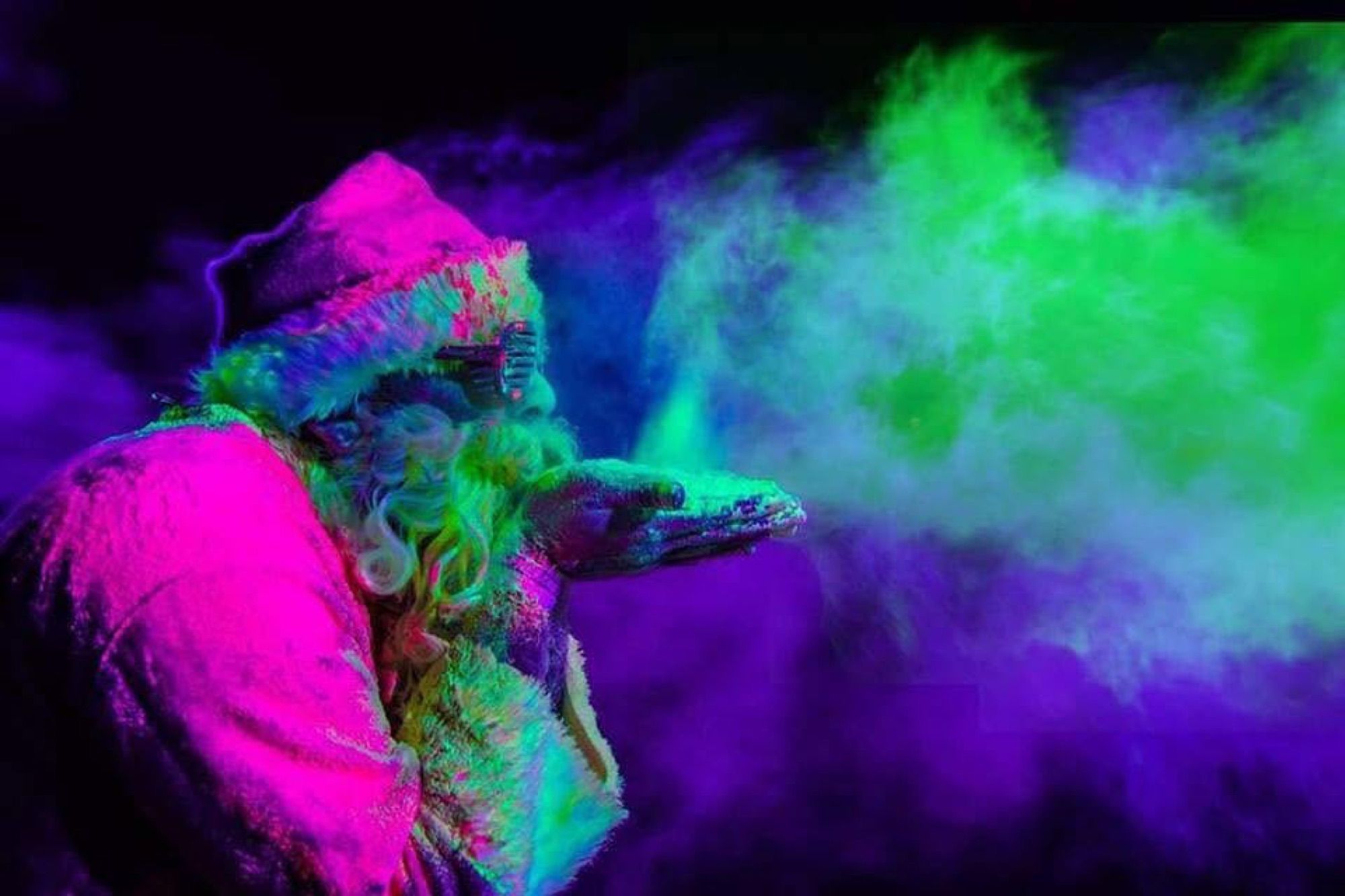 Santa-costumed runner blowing glowing green powder into the air